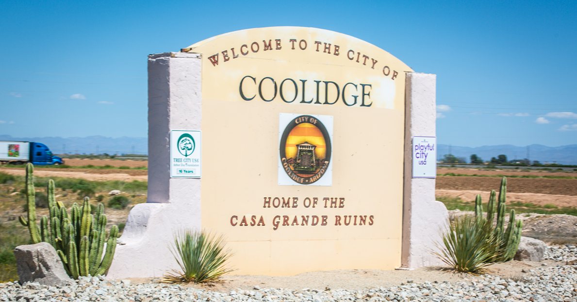The City of Coolidge welcome sign, home of the Casa Grande Ruins, with cacti and blue sky